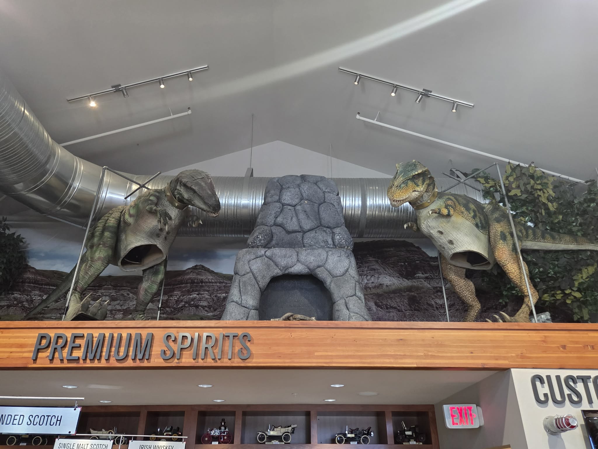 Two raptors flanking a stone arch over the Premium Spirits section