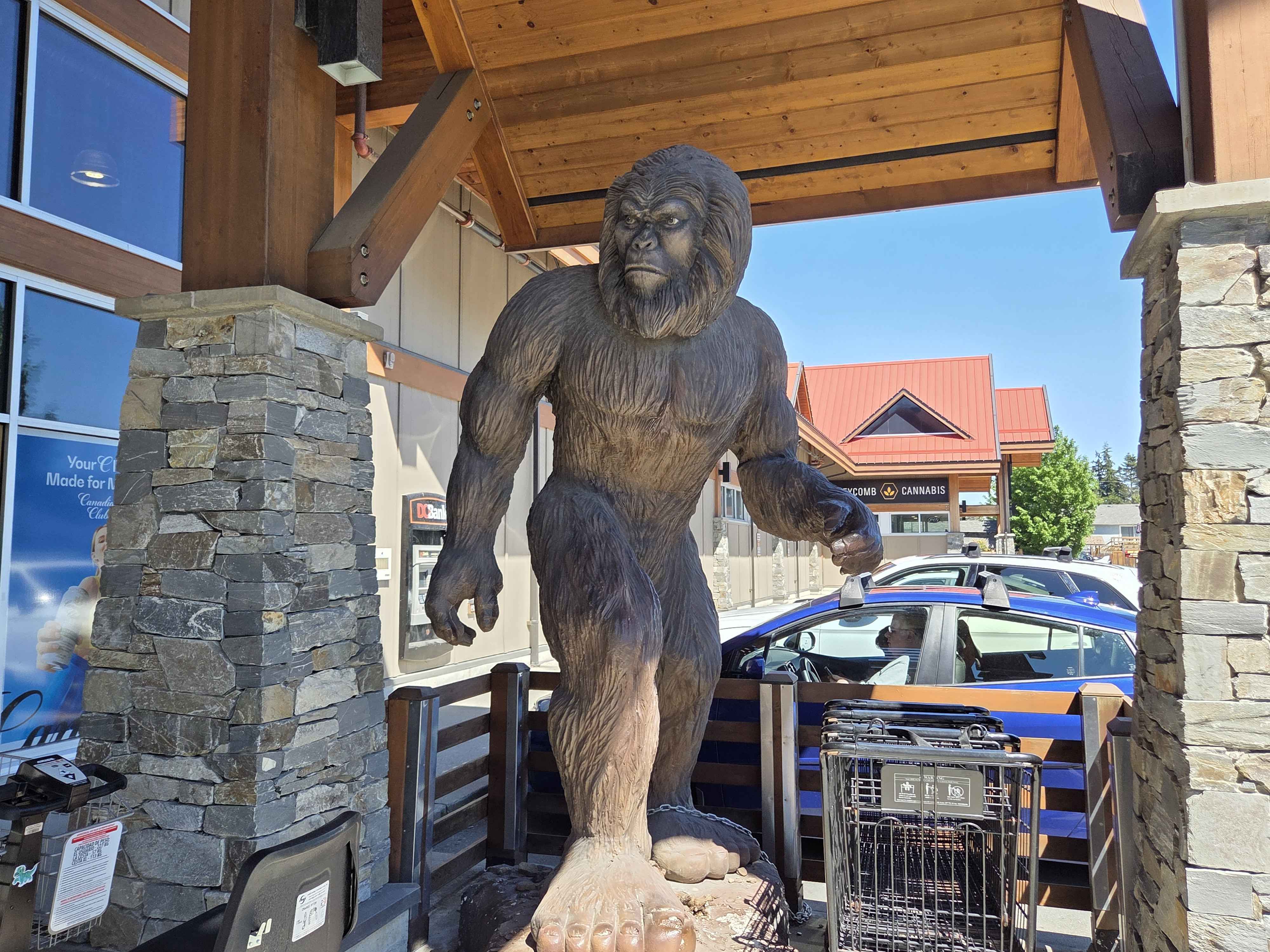 A wooden carved Bigfoot statue standing under the entrance overhang