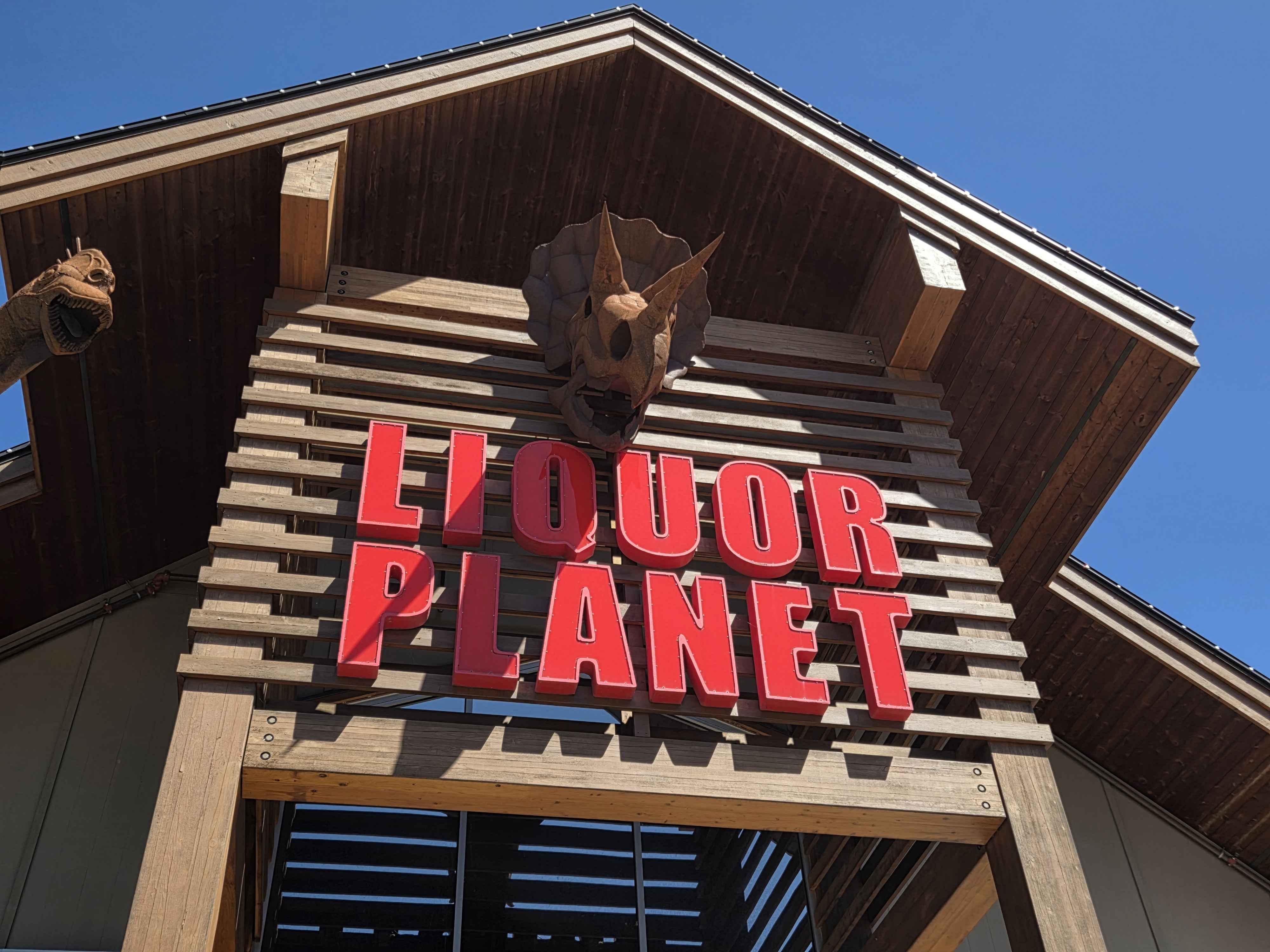 A Triceratops bust mounted above the giant Liquor Planet exterior sign