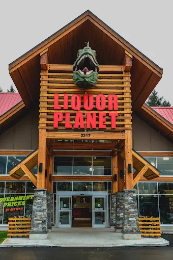 The Liquor Planet front entrance with the 10-foot T-Rex head mounted above the giant LIQUOR PLANET sign and double doors below